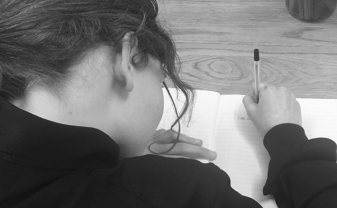 Young girl writing in her notebook