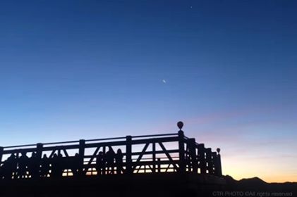 A bridge with a beautiful sunset in the background, the sky nearly dark but the sun just visible on the horzone