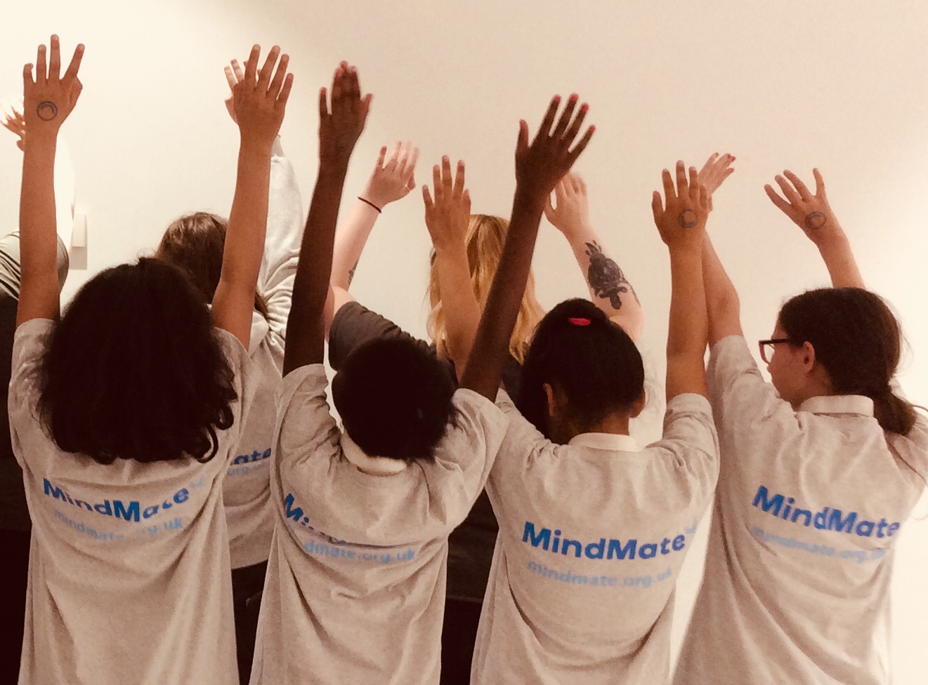 Group of young girls with hands in the air wearing MindMate shirts