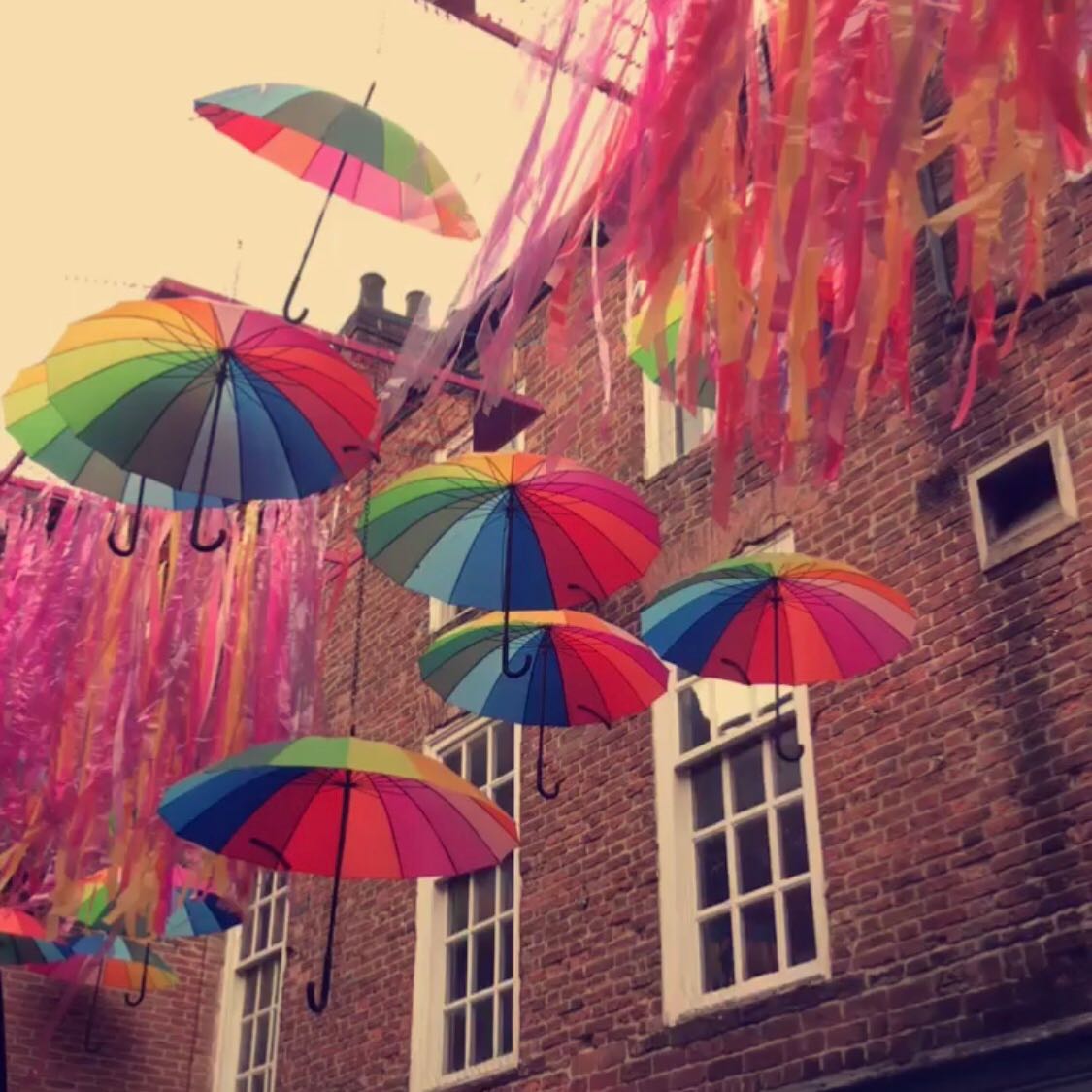 rainbow umbrellas hanging in the street