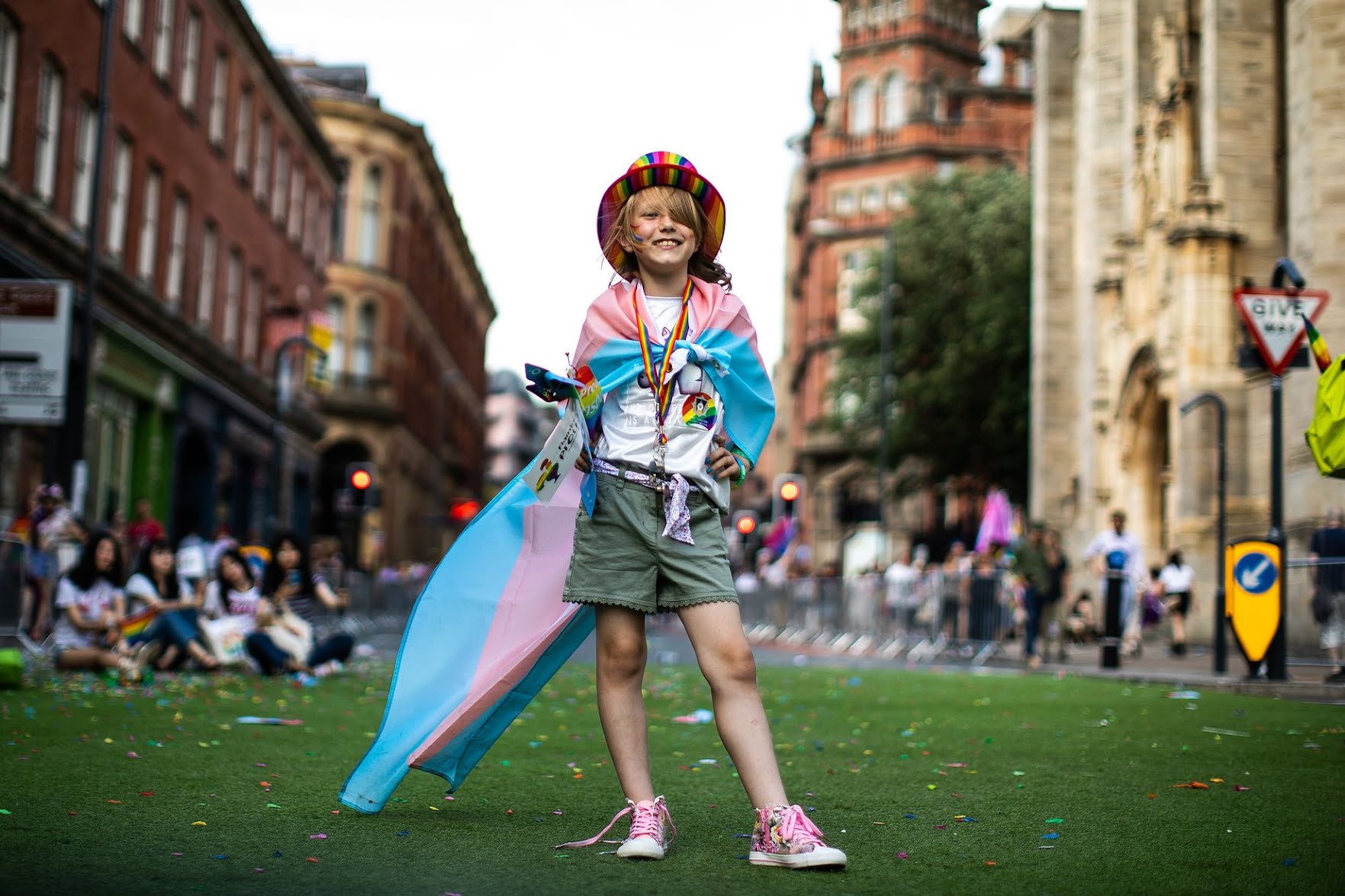 Young person wearing pride flag and hat